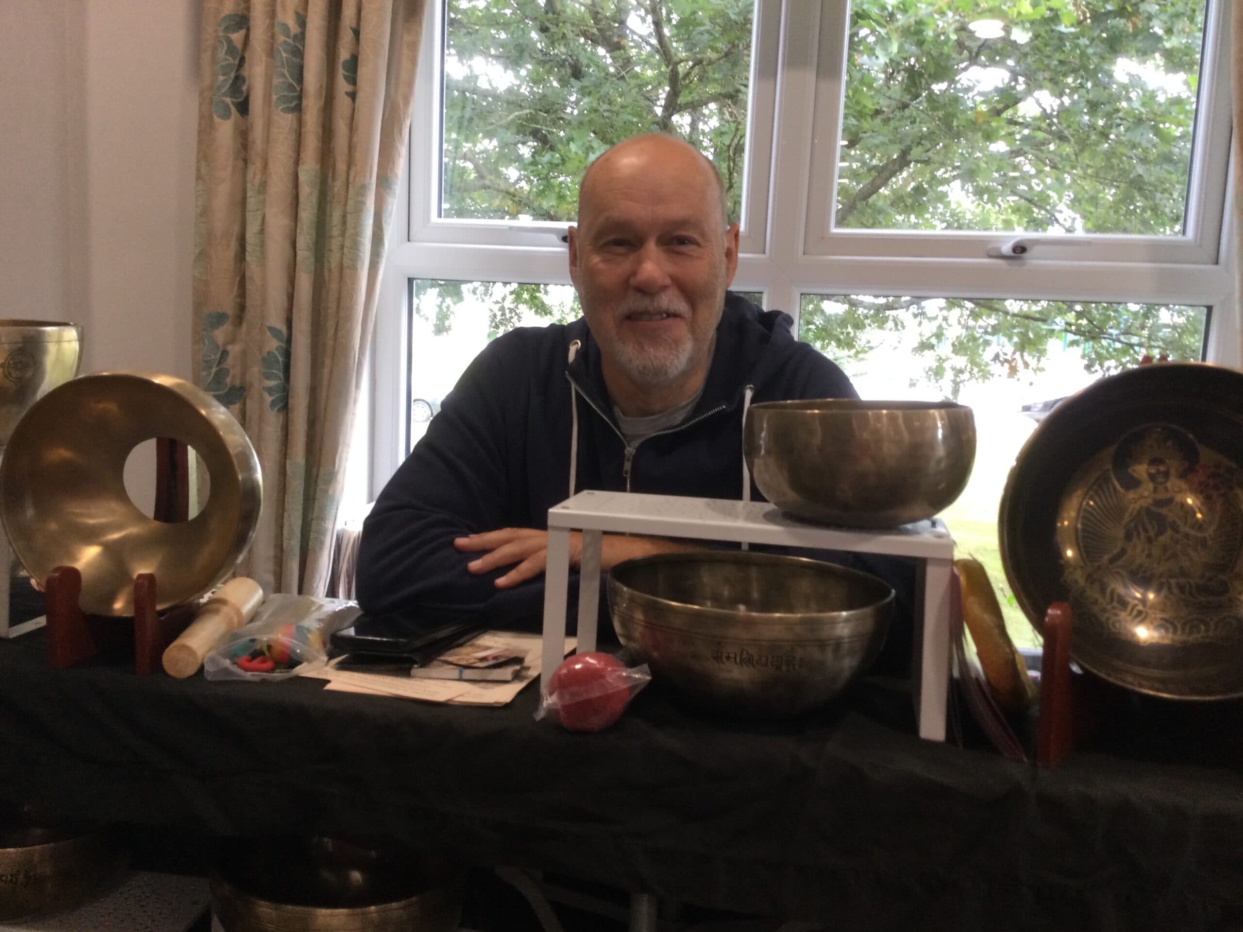 Singing bowls practitioner by the window
