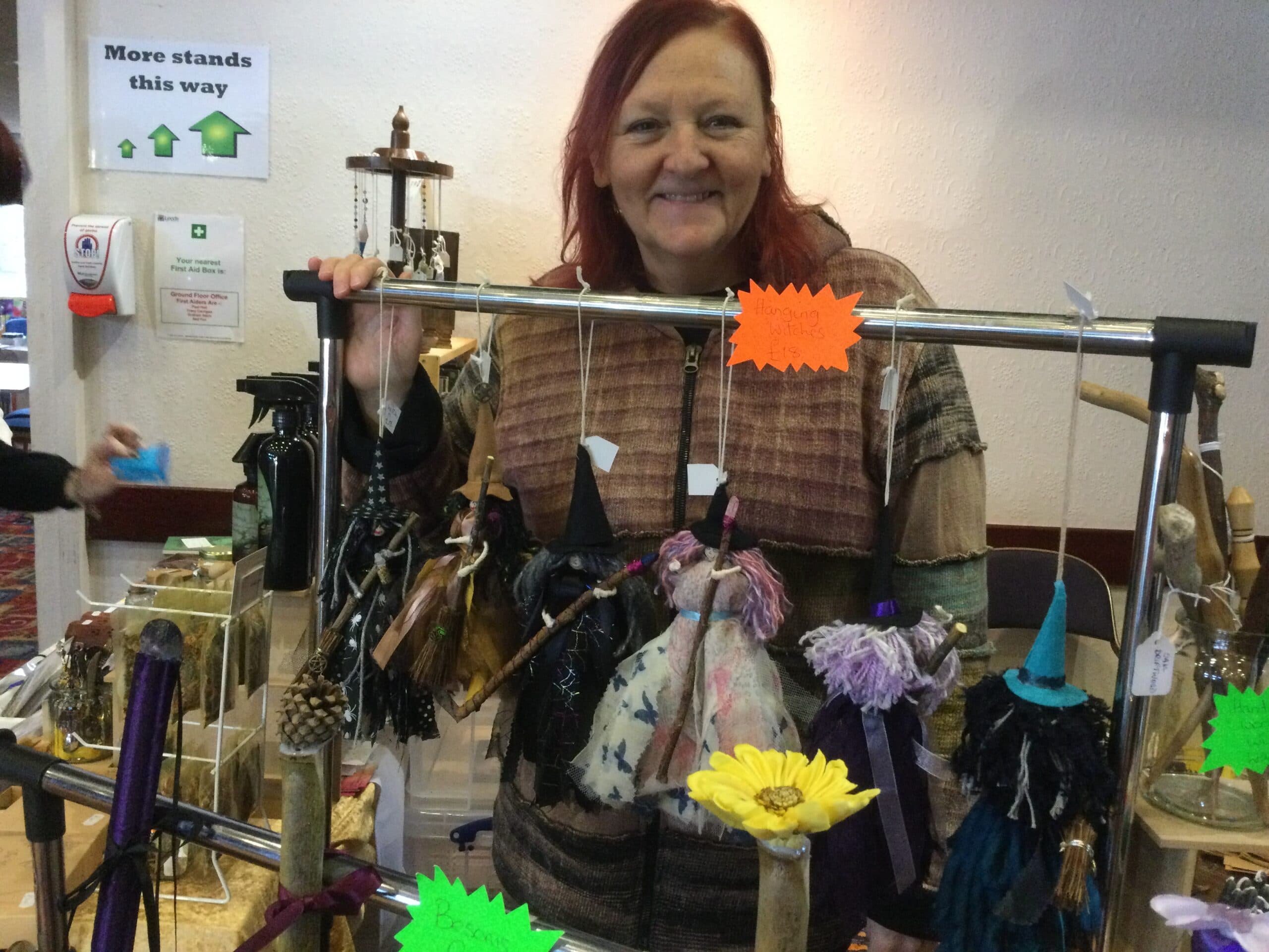A maker with her handmade hanging witches