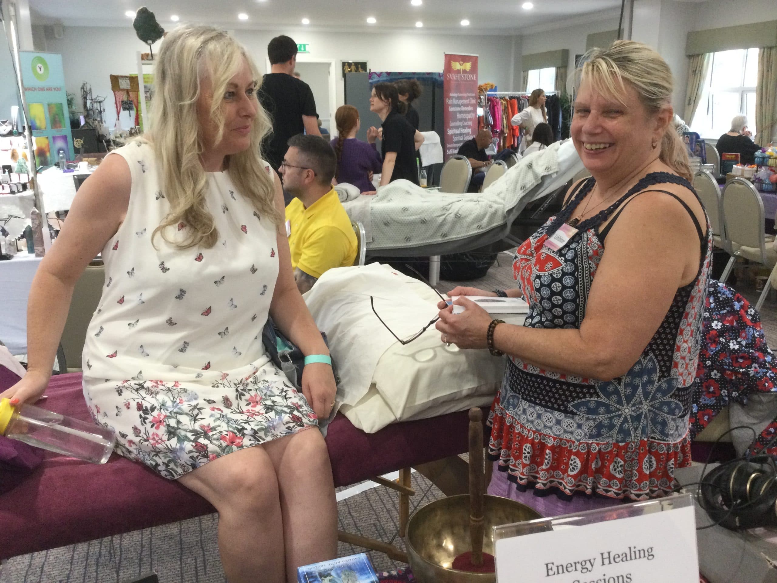 An energy healing session at a festival stand